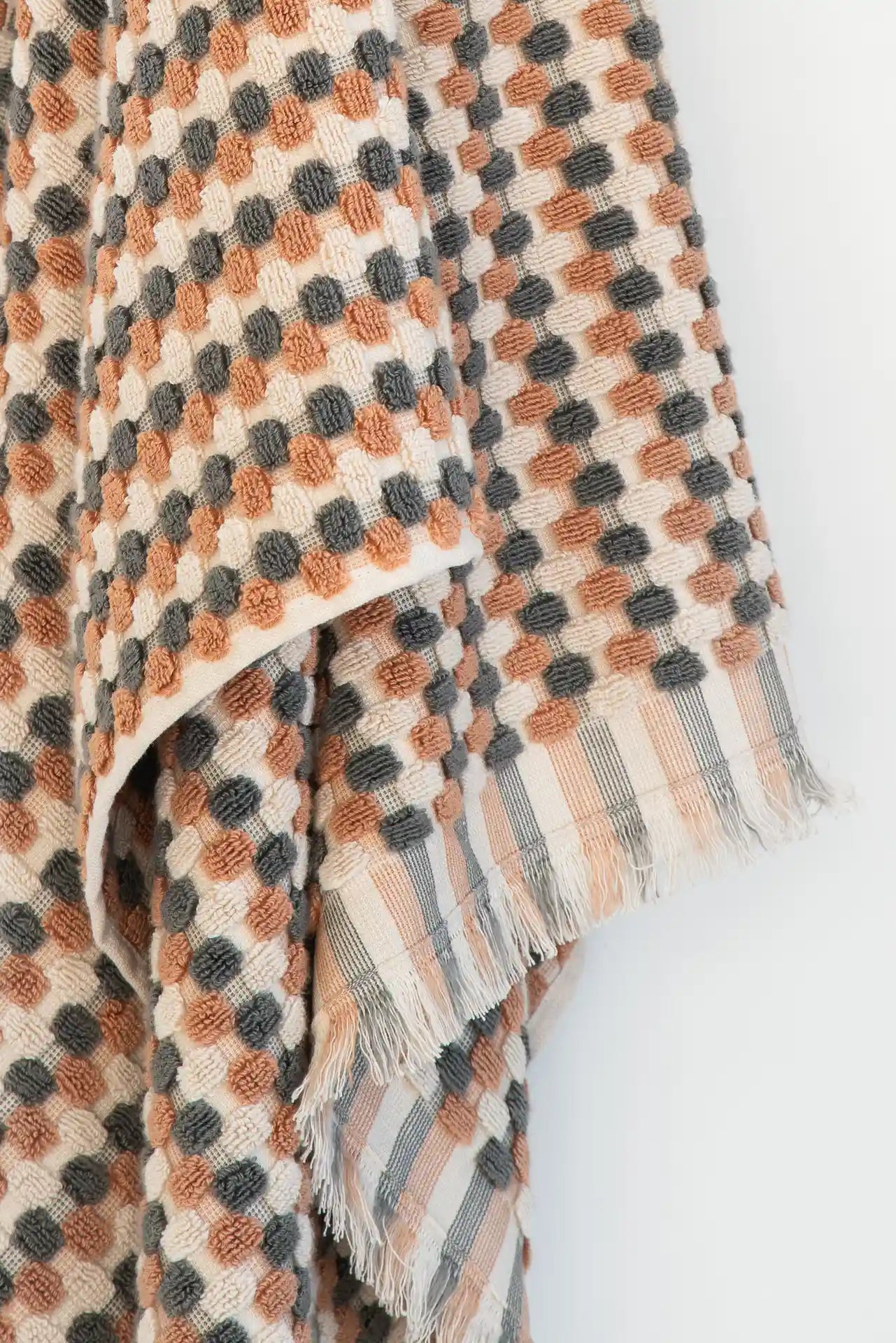 Plaid patterned fabric with earthy tones on a white background