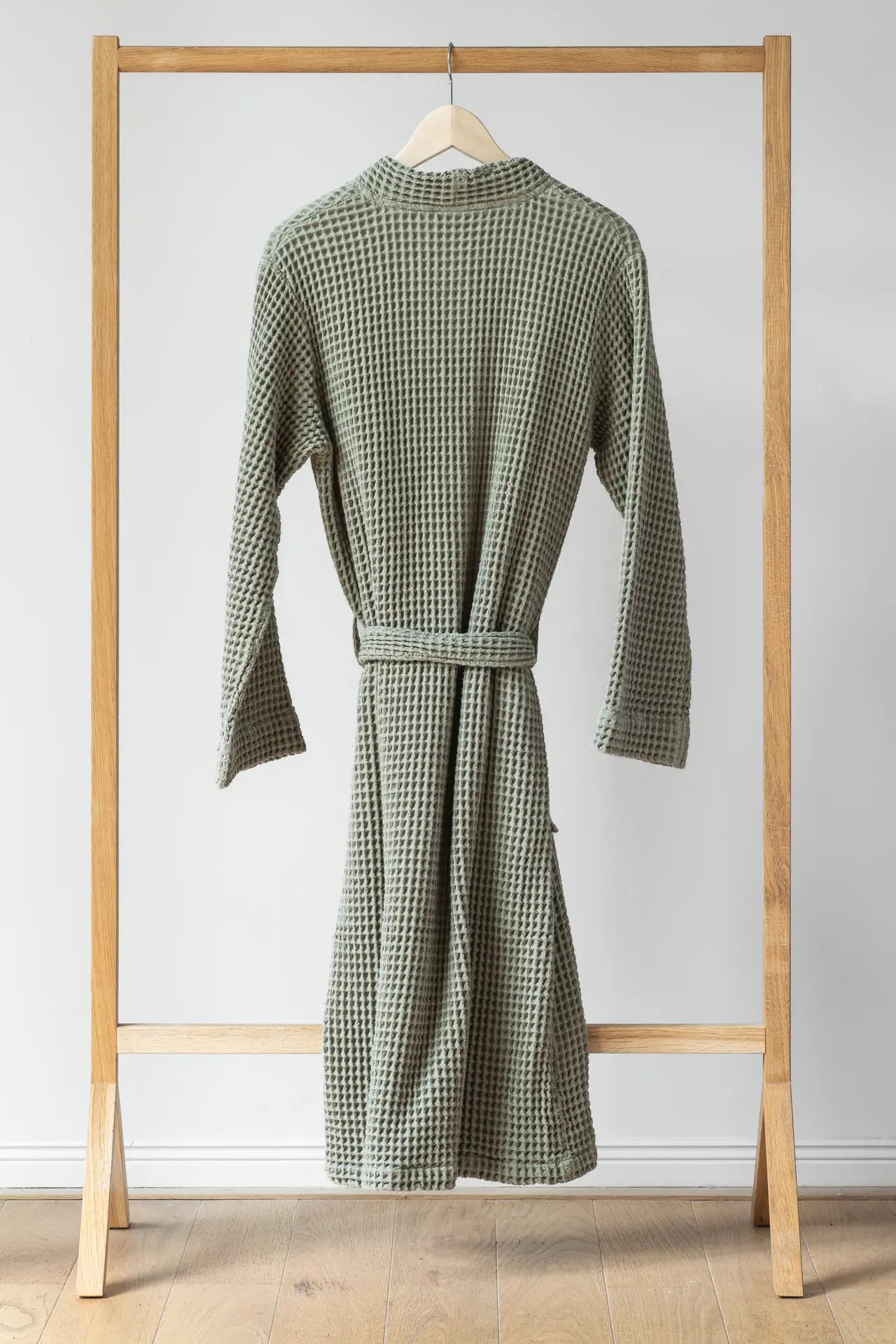 Backside of the moss green bathrobe is hung