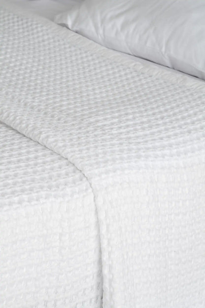 White textured bed sheet on a bed