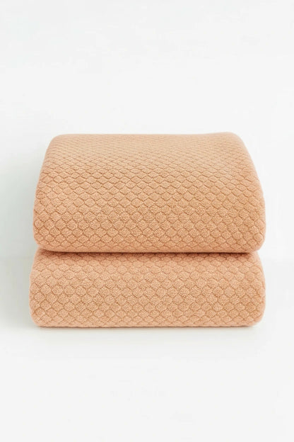 two natural colored towels are displayed as a set