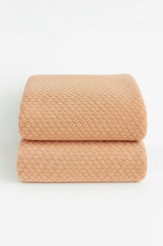 two natural colored towels are displayed as a set